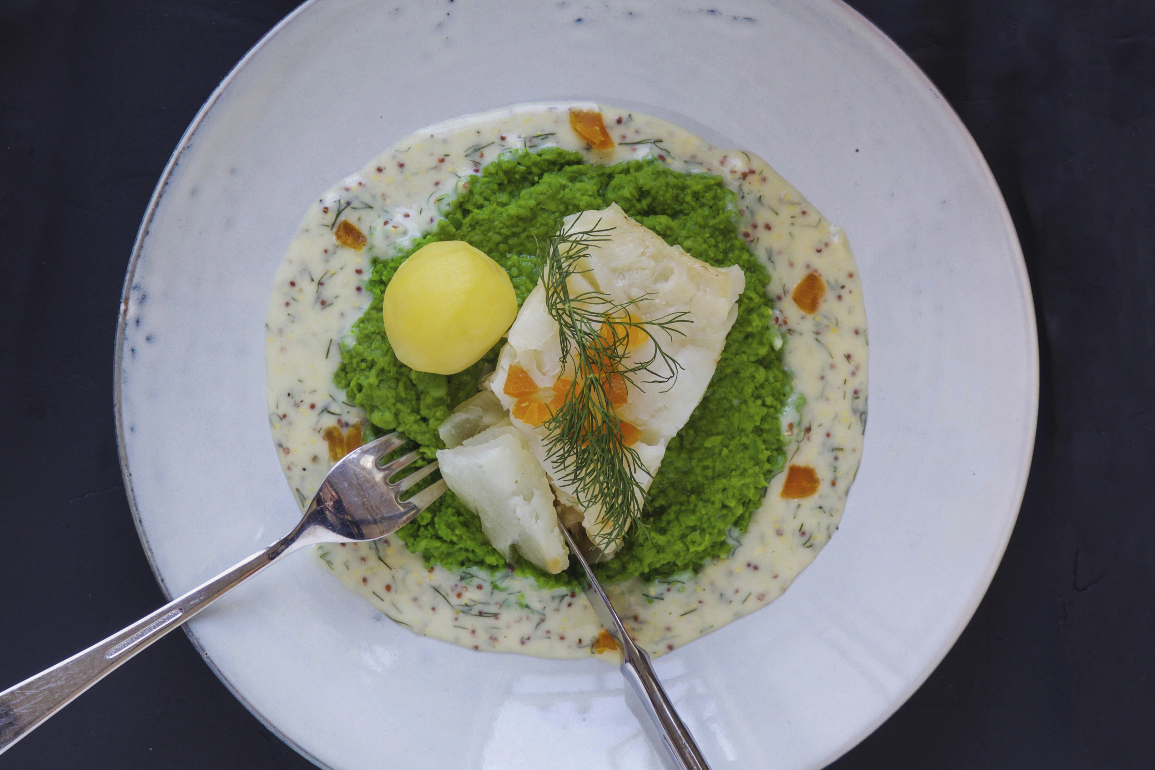 Fried salmon with salad and sesame seeds on a plate placed on a  nicely set table